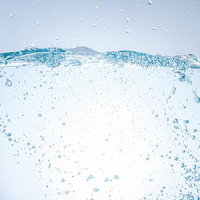 細かい気泡が透明な水の中を漂う清潔で爽やかなミネラルウォーターの写真