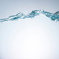 水槽からあふれる清涼な水流と気泡の流れ、ミネラルウォーターの写真