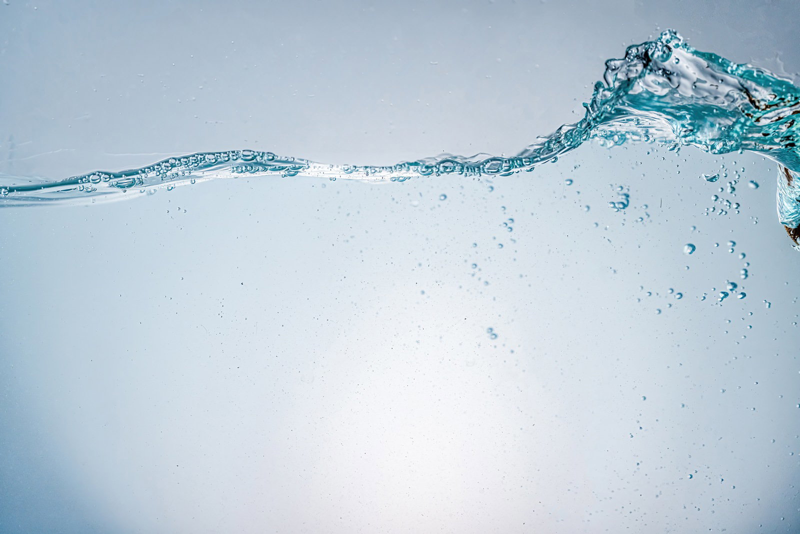 水槽で大きく盛り上がる波と気泡が浮かぶ透明な水