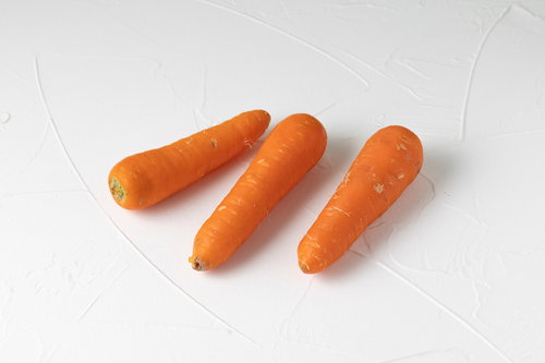 葉を落とした調理前のニンジン3本のオレンジ色野菜