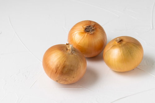 白い背景に転がる三個の玉葱
