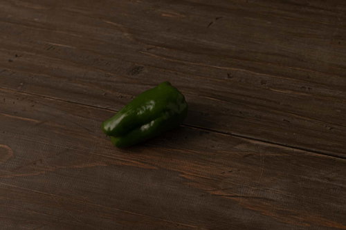 木目調のフローリングに落ちた緑色のピーマン