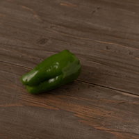 木製テーブルに取り残された新鮮なピーマンの写真