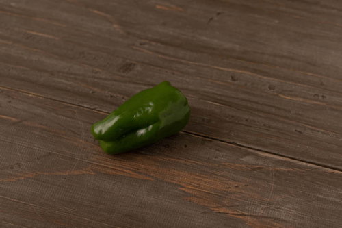 木製テーブルに取り残された新鮮なピーマン