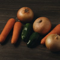 料理用に厳選された玉葱と人参とピーマンの3種類の野菜の写真