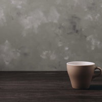 木目調のテーブルに残るコーヒーカップの飲料の写真