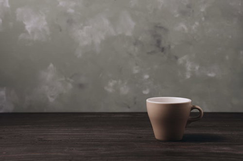 木目調のテーブルに残るコーヒーカップの飲料