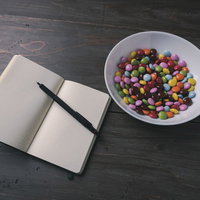 白紙の手帳とカラフルなマーブルチョコレートの写真