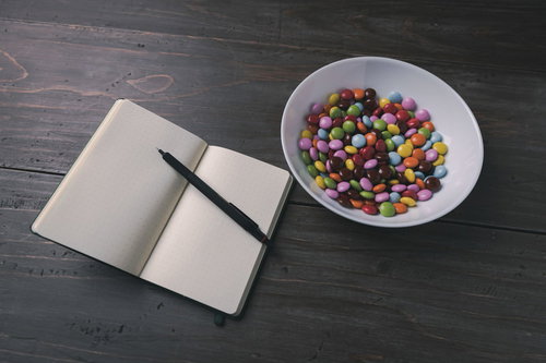 白紙の手帳とカラフルなマーブルチョコレート