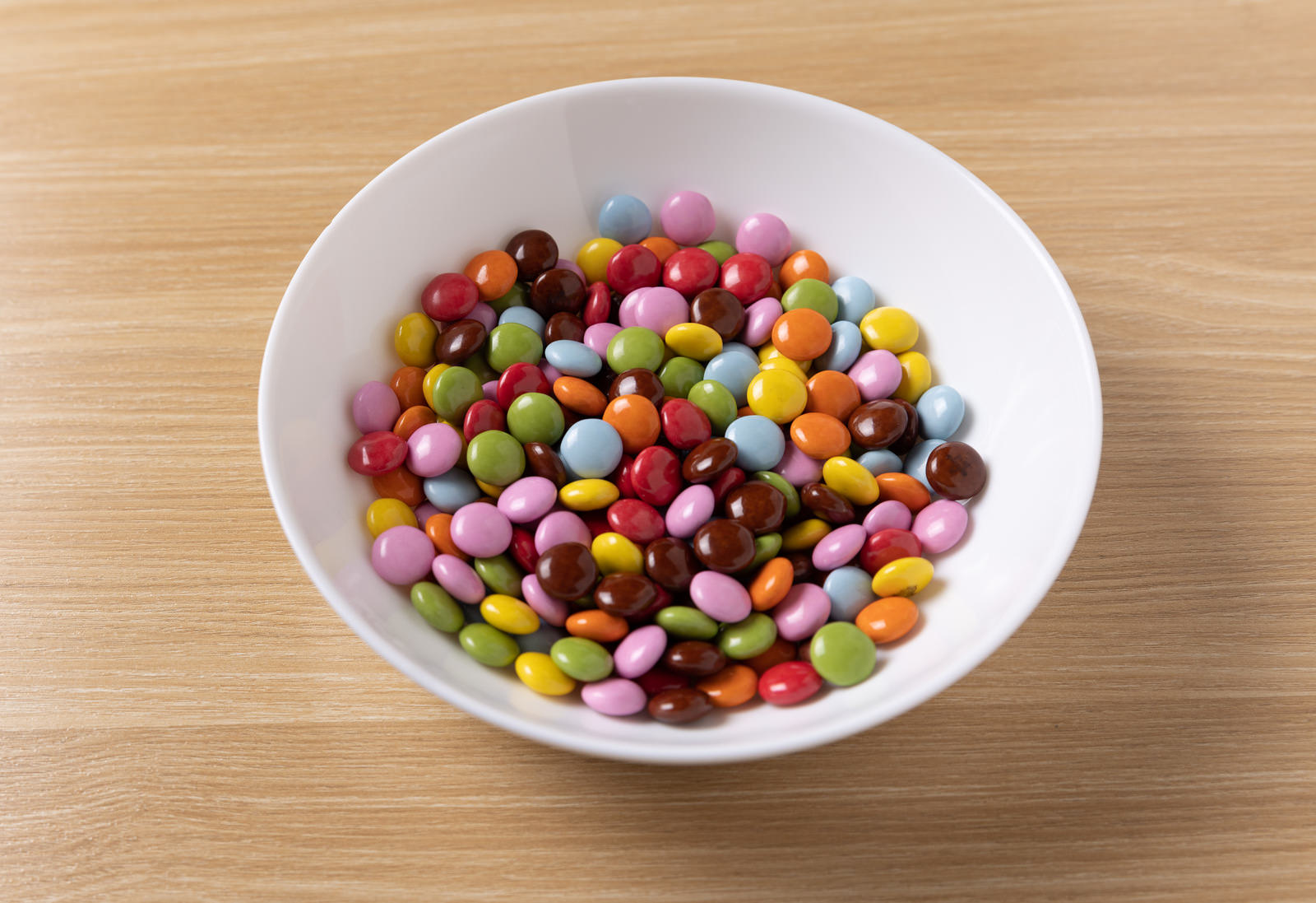 白い皿の上に盛られた複数の色のマーブルチョコレート
