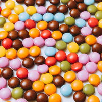 赤・青・黄色が混在したマーブルチョコのテクスチャーの写真