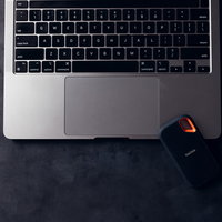 MacBookと黒い外付けストレージデバイスの写真