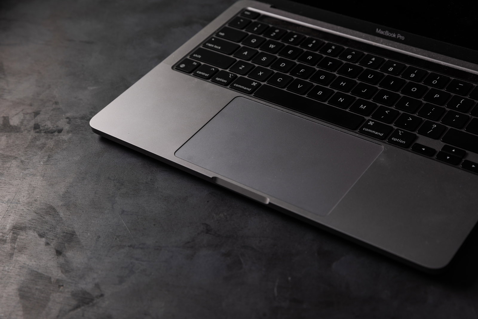MacBook Proのシルバーボディに黒いキーボードとタッチパッドが配置された様子