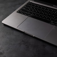 MacBook Proのシルバーボディに配置された黒いキーボードの写真