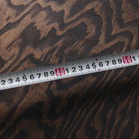 豹柄の生地の上に置かれたメジャーで長さを計測しているの写真