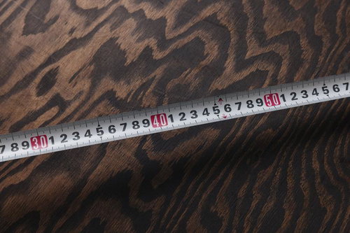 豹柄の生地の上に置かれたメジャーで長さを計測している