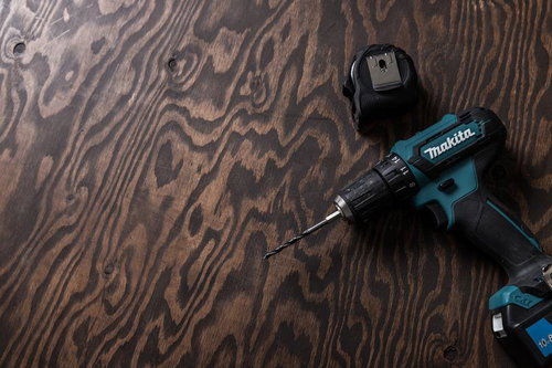 木目の作業テーブルの上に置いたマキタの電ドル
