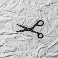 白い布地の上に置かれた黒いハサミ、手芸やクラフト向けの写真