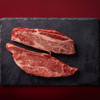 黒いスレート皿に並ぶ霜降り松阪牛のサーロインステーキの写真