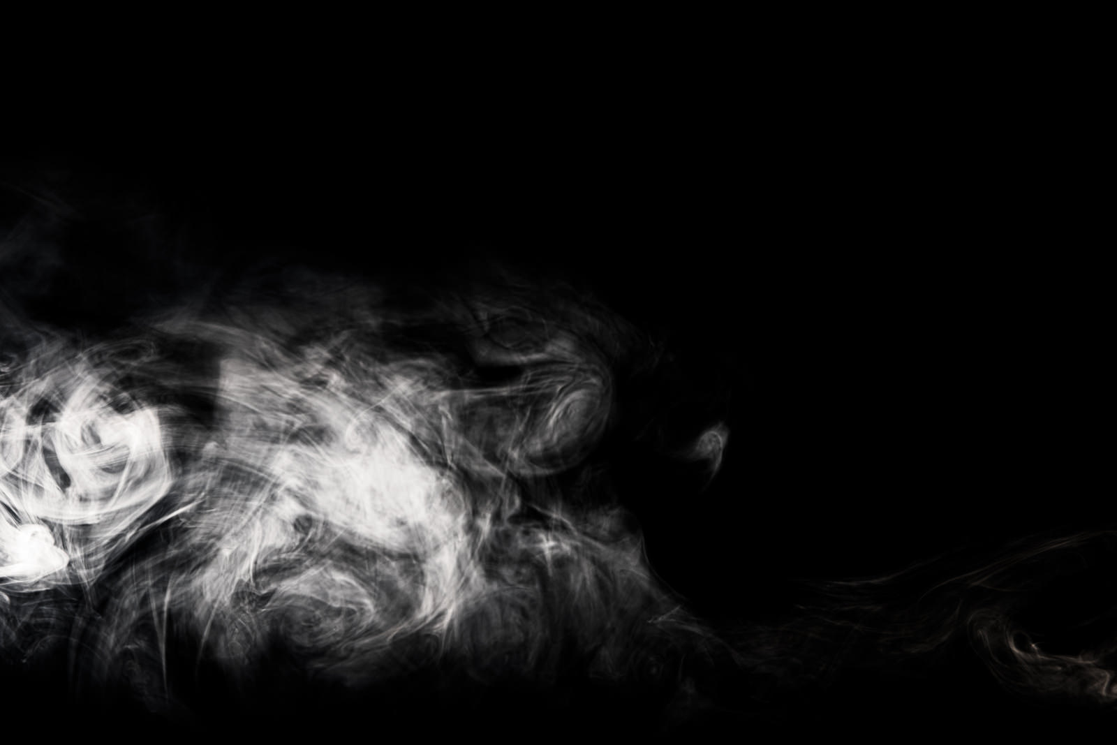 黒い背景に白い煙が渦巻きながら立ち昇っている様子
