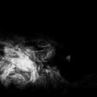 渦巻く白い煙が黒背景に立ち昇る抽象的なスモークの写真
