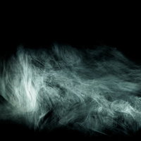 黒い背景に立ち込める流れ出る不穏なガスと煙の写真