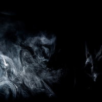 黒い背景に立ち昇る消えかけたスモークと白煙の写真