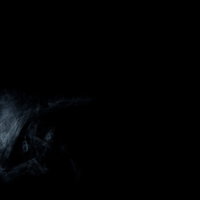 暗闇に立ち上る薄い白い煙のもくもくした流れの写真