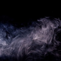 黒背景に噴出した白い煙のもくもくとした流れの写真