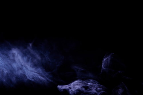 暗闇に立ち上るかすれた紫と青のスモークの背景