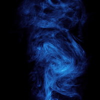 不穏に渦巻く青いスモーク｜黒背景の濃淡コントラストの写真