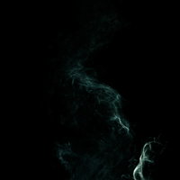 もやもやした緑色の煙が暗闇に立ち上るの写真