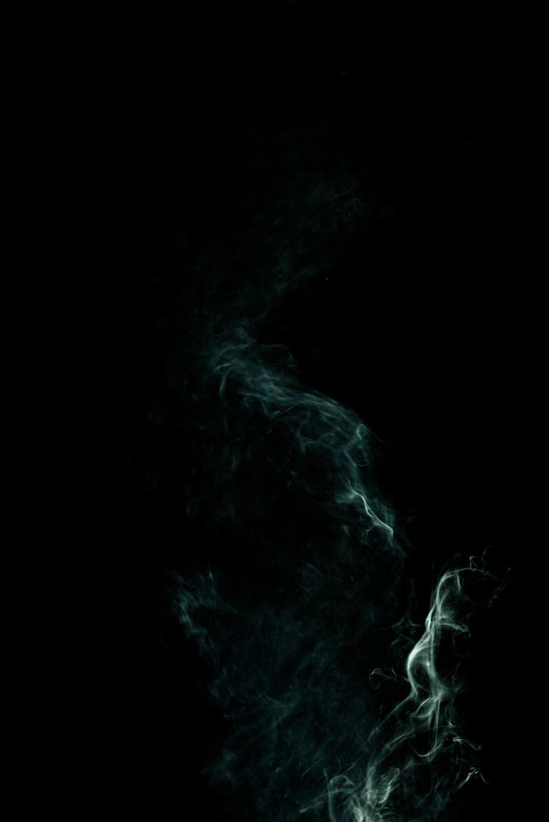 黒い背景に緑色の煙が縦に立ち上っている様子
