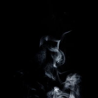 黒い背景にゆらゆら昇る白い煙の写真の写真