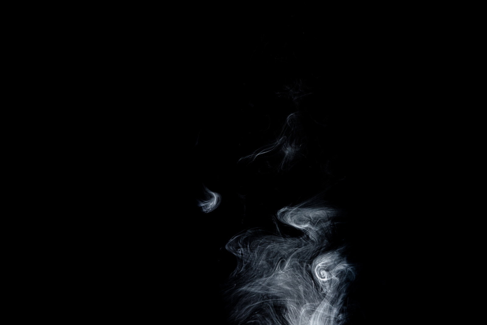 黒い背景に立ち上る白い煙が幻想的に写された写真