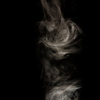 上から下に流れる煙幕の白い煙 黒背景 スモークの写真