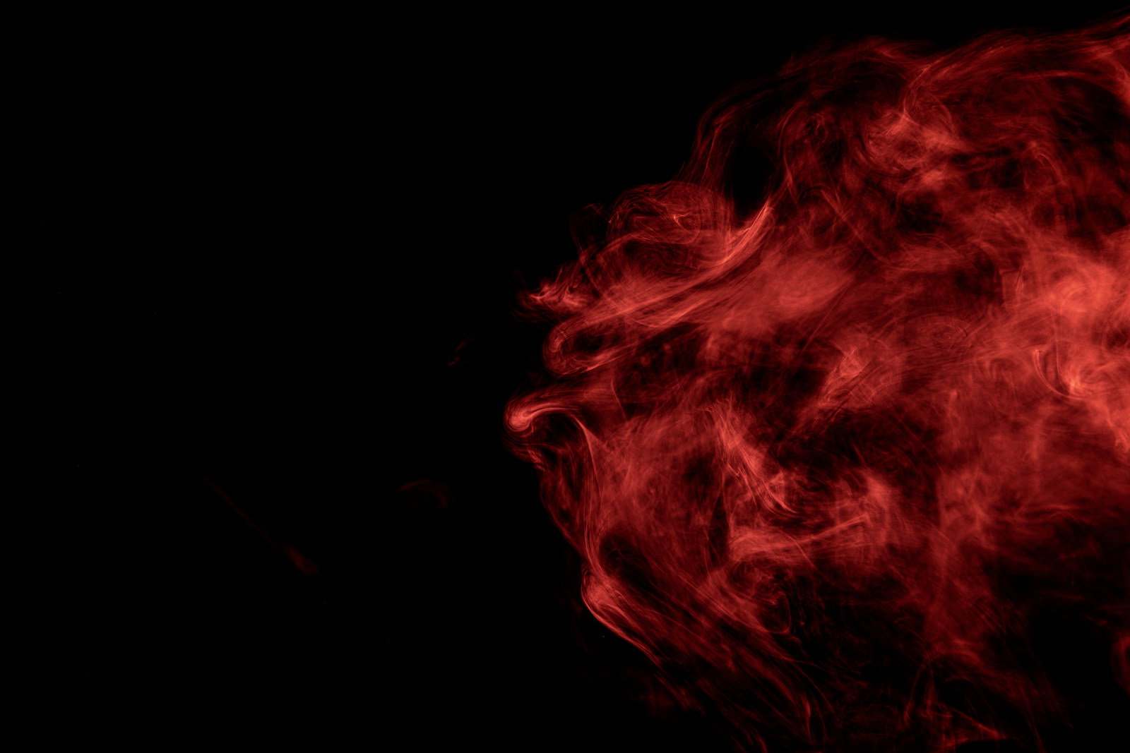 黒い背景に立ち上がる赤い煙