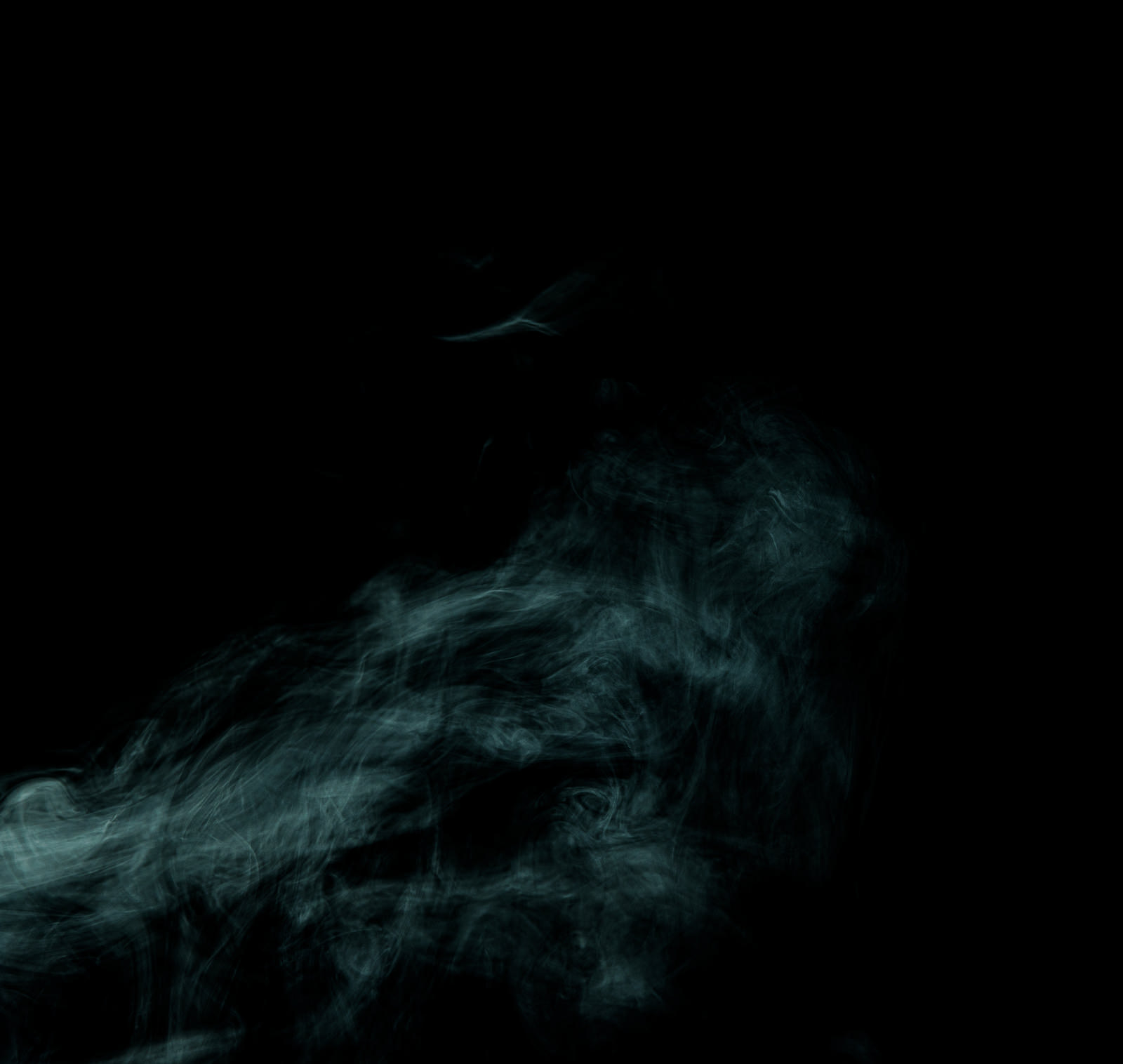 黒い背景に緑色の煙が立ち上る幻想的な写真