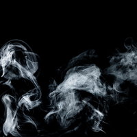 黒い背景にもわもわと広がる白い煙のスモークの写真