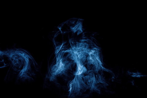 黒い背景に立ち上る青い煙と冷気の写真