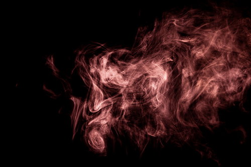 黒い背景に立ち上がる赤い不穏な煙幕と毒ガス