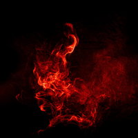 黒い背景にバーストする赤とオレンジの炎と煙の写真