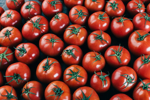 緑の茎がついた新鮮なミニトマトがいっぱい詰まった野菜