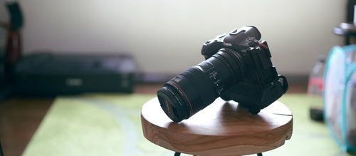 小さい木製テーブル上のCanon EOS R5ミラーレス一眼レフカメラ