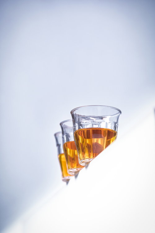 白い背景に縁に並んだグラスに入った琥珀色のお茶