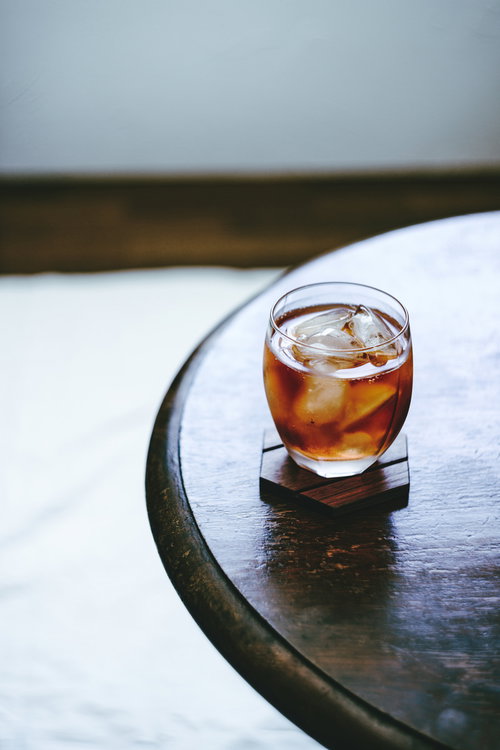 白い机の上に置かれたアイスティーとグラス