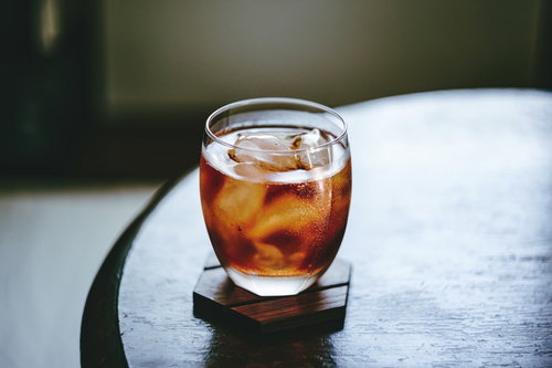 グラスに注がれた冷たい麦茶と氷、木製テーブル