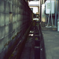 住宅街の家と家の間にある側溝と境界線の写真