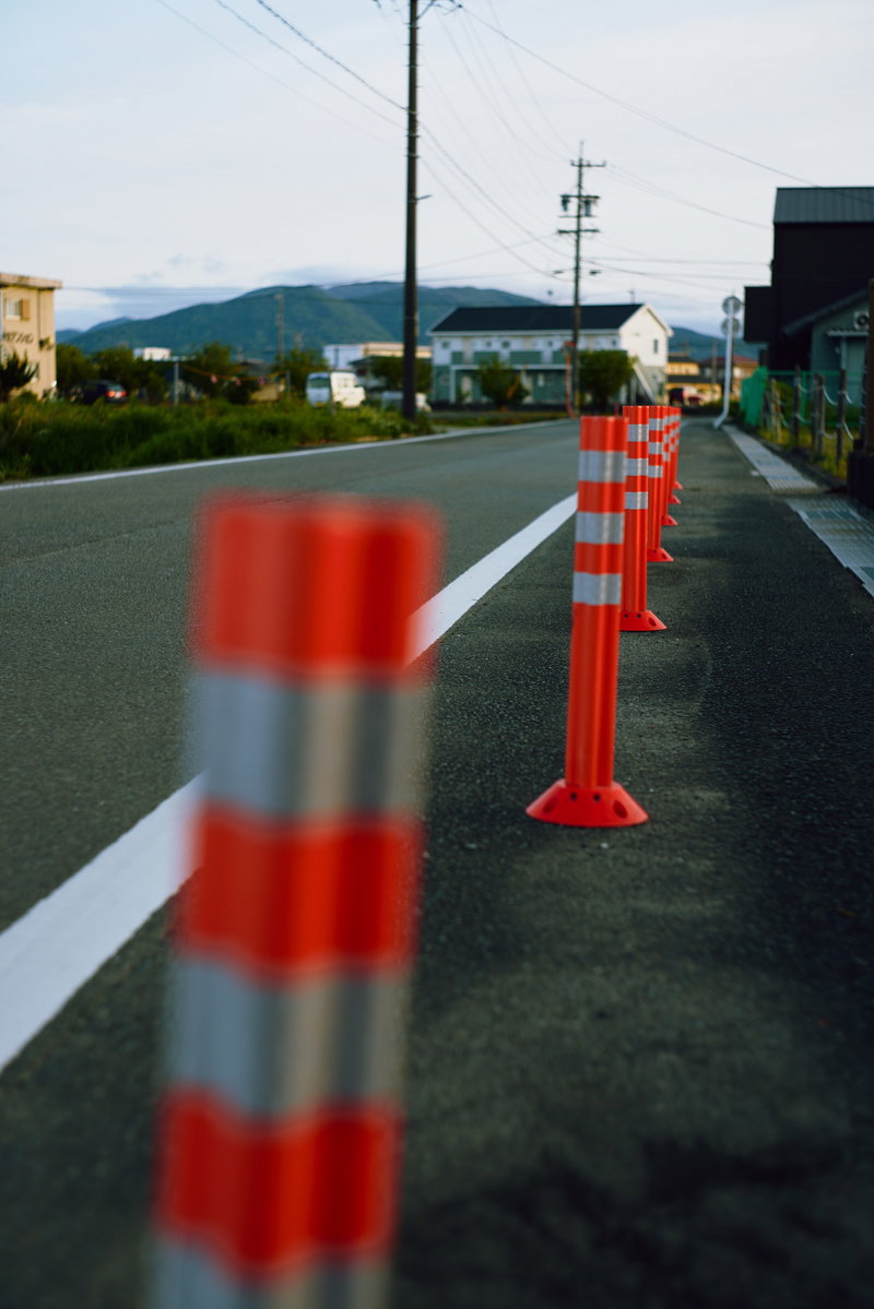 歩道に立つ赤と白のストライプ模様のポストコーン