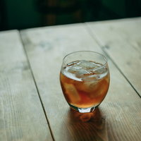 縁側に置かれた冷たい麦茶をグラスで飲む夏の情景の写真